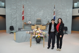 Augustin Lacoursière-Barthe (Youth Parliamentarian MLA Yellowknife North) standing beside the Mace.